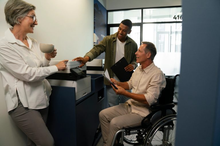 A woman assists a man in a wheelchair, providing support as he navigates his surroundings.