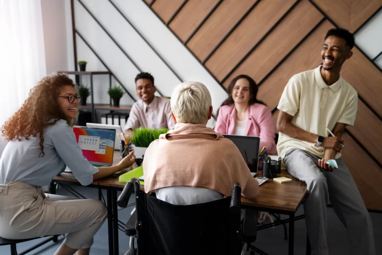 Several individuals gathered at a table, focused on their laptops, engaged in a productive discussion.
